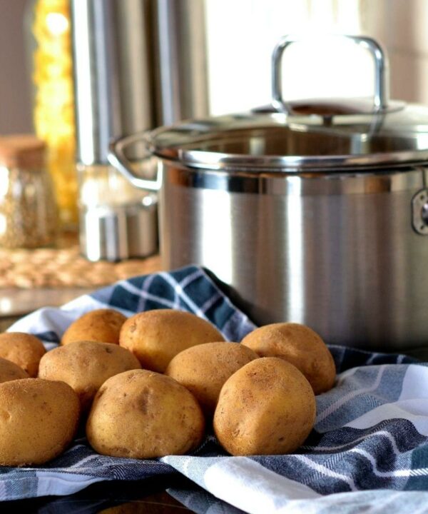 potatoes on a blue towel in front of a large pot